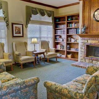 A cozy living room with a fireplace, bookshelves, and comfortable seating.