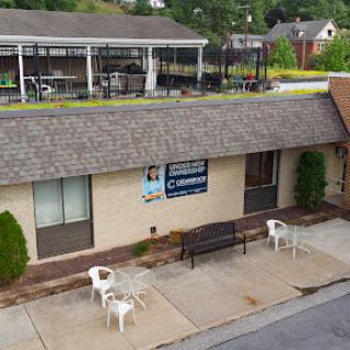 A view of a business building with outdoor seating and clear signage.