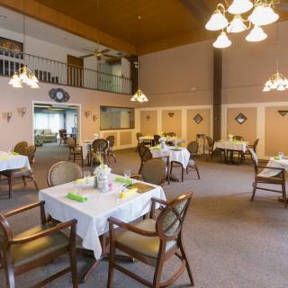 A cozy dining room interior with several tables set for a meal.