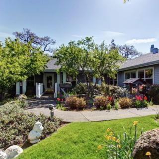 A charming house with a well-maintained garden and lush greenery.