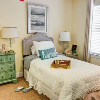 A cozy bedroom with a single bed, nightstand, and decorative elements.