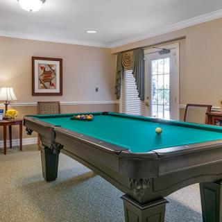 A well-lit billiard room featuring a pool table and elegant decor.