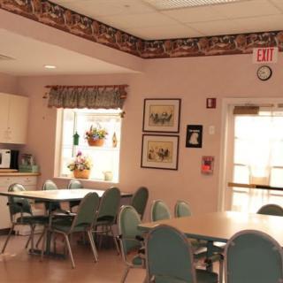 A cozy dining area with tables and chairs, adorned with wall decorations and a clock.