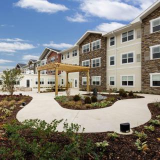 A modern residential apartment building with landscaped pathways and gardens.