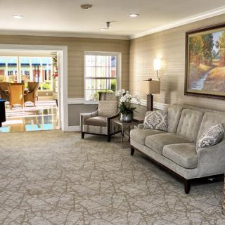A cozy living room featuring a comfortable sofa, a stylish coffee table, and artistic decor, illuminated by natural light.