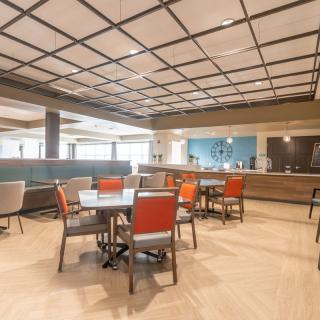 A modern dining area with tables and chairs, featuring a stylish ceiling design.