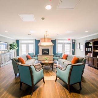 A cozy living room with a central seating area and a fireplace, featuring elegant furniture and modern decor.