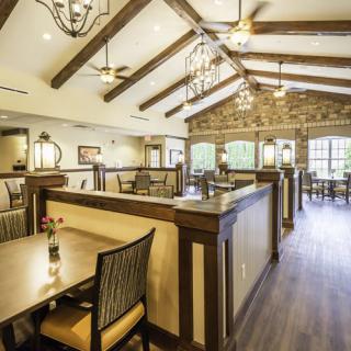 Elegant restaurant interior with wood-beamed ceiling and chandeliers.