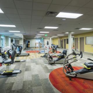A well-equipped gym featuring various exercise machines and a spacious interior.