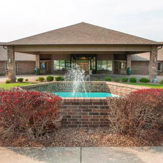 Front view of a building with a central fountain and well-maintained landscaping.