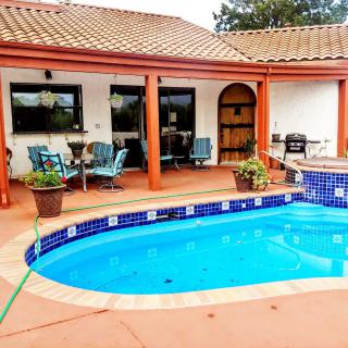 A cozy backyard patio featuring a small pool, comfortable outdoor seating, and a barbecue grill.
