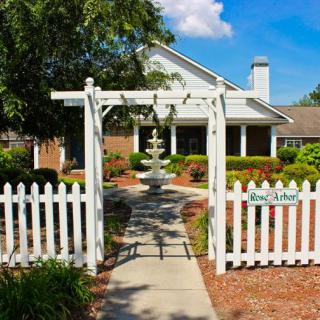 A charming house with a white picket fence and a garden fountain.