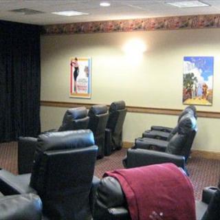 A cozy home theater room with comfortable recliner seating and movie posters on the walls.