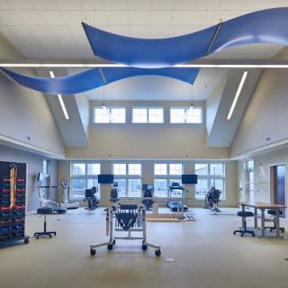 A spacious and modern rehabilitation center equipped with various exercise machines and tools.