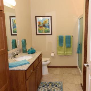 A well-organized bathroom with vibrant decor and a modern shower.