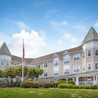 A residential building with a manicured lawn and clear blue sky.