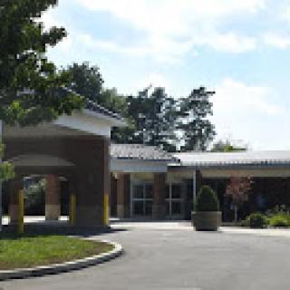 A well-maintained entrance of a building surrounded by greenery.