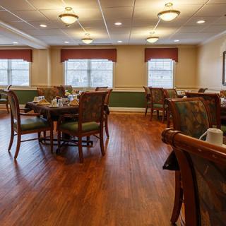 A well-lit dining room with neatly arranged tables and chairs, creating an inviting atmosphere.