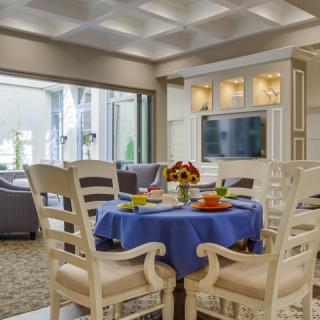 A well-decorated dining area with a blue tablecloth, adjacent to a cozy living room.