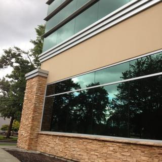 A modern building with reflective glass windows and a brick facade.