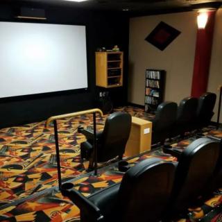 A cozy home theater with comfortable seating and a large screen.