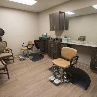 A modern hair salon interior with chairs, mirrors, and a sink.
