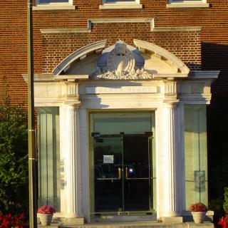 An ornate building entrance with columns and decorative elements.