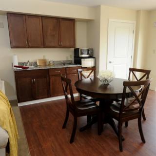 A cozy kitchen and dining area with wooden cabinetry and flooring.