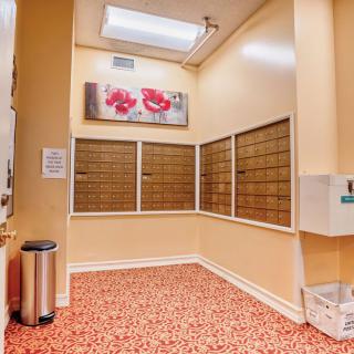 A neatly organized mail room with multiple mailboxes and decorative artwork on the wall.