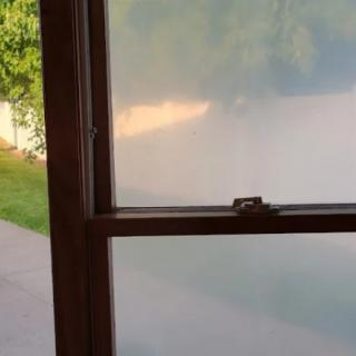 A view through frosted glass showing a blurred outdoor scene.