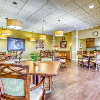 A well-lit dining area featuring wooden tables and chairs, with decorative elements on the walls.
