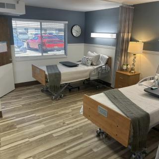 A hospital room with two patient beds and modern interior design.