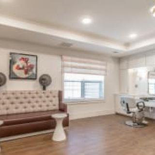 A modern hair salon interior with seating and styling stations.
