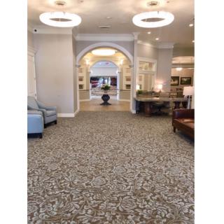 A spacious lobby area featuring elegant lighting, comfortable seating, and a decorative archway.