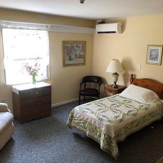 A cozy bedroom with a single bed, window view, and simple decor.