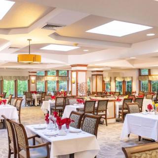 Elegant dining room with neatly arranged tables and warm lighting.