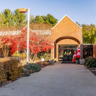 A festive entrance adorned with autumn foliage and a cheerful Santa Claus figure.