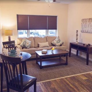A cozy living room with a sofa, coffee table, and wooden furniture.