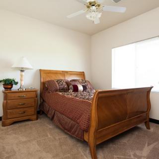 A cozy bedroom with a wooden bed, nightstand, and elegant decor.