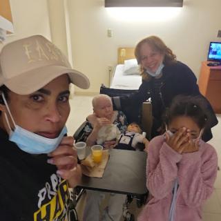 A heartfelt moment shared in the hospital, capturing family and caregivers supporting a loved one.