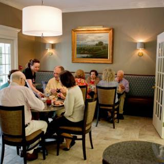 A lively gathering of friends enjoying a meal together in a cozy dining setting.