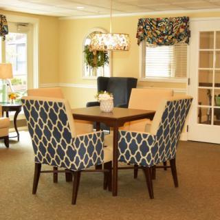 A cozy dining room with a wooden table and patterned chairs.