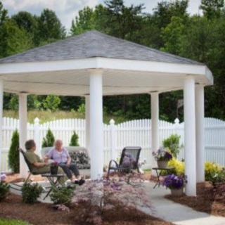 A cozy gazebo in a garden setting with seating for relaxation.
