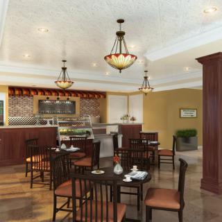 A cozy cafe interior with tables, chairs, and warm lighting.