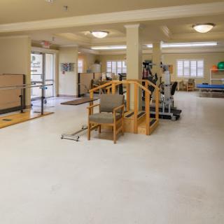A spacious rehabilitation therapy room equipped with exercise equipment and accessibility features.