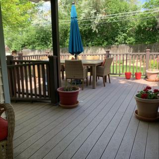 A tranquil backyard patio with outdoor furniture and potted plants.