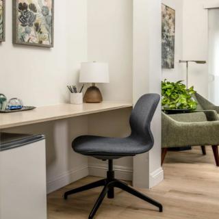 A modern home office setup with a desk, comfortable chair, and decorative elements.