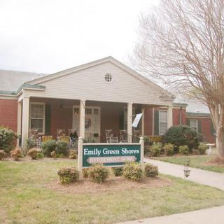Front view of a nursing home with a welcoming entrance and landscaped surroundings.