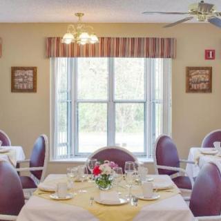 A bright dining room with elegantly set tables and a large window.