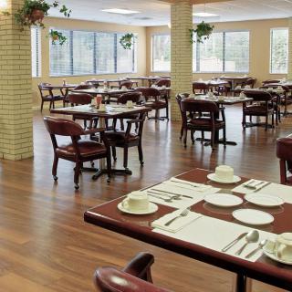 An empty restaurant dining area with neatly arranged tables and chairs.